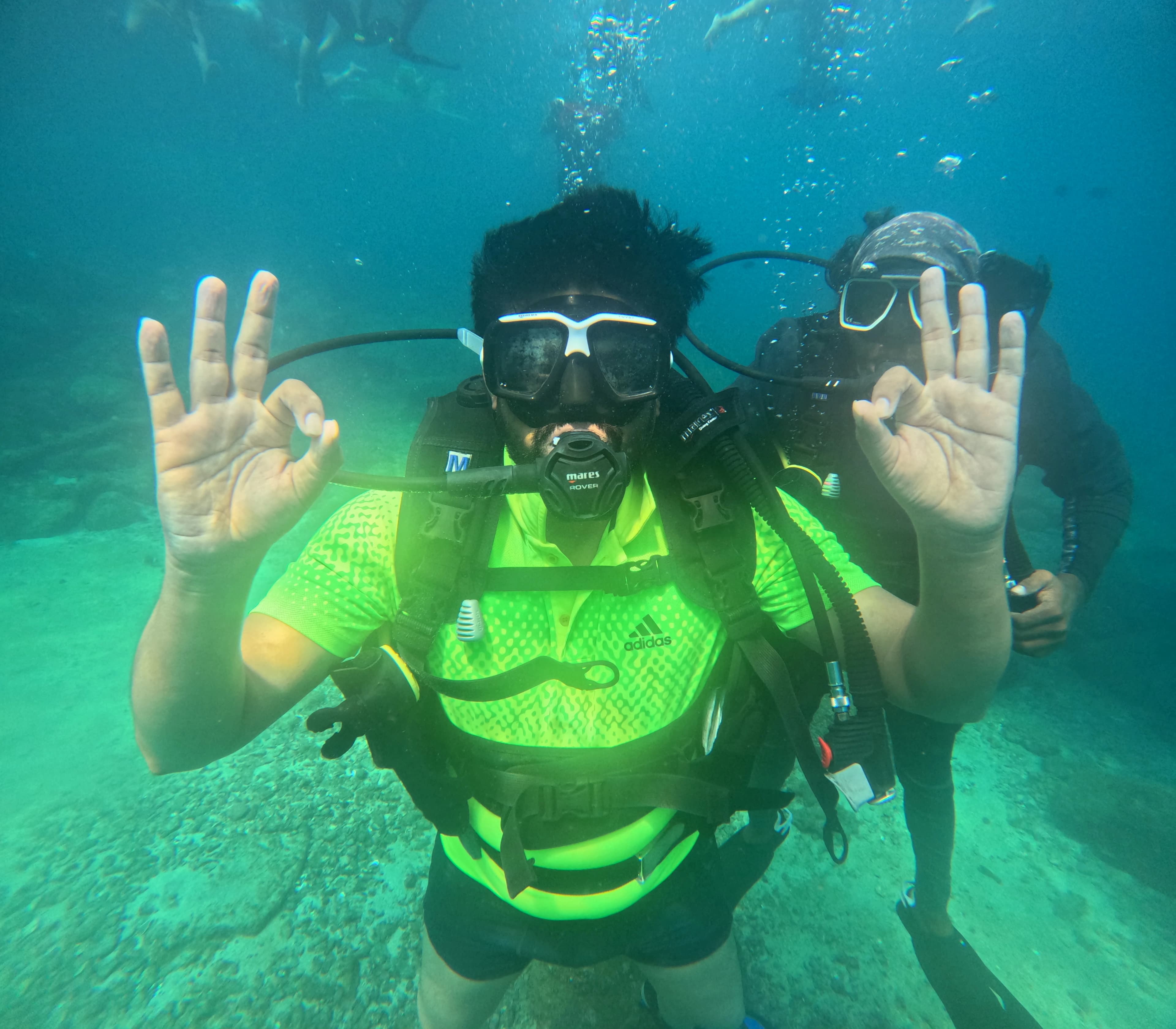 Diver practicing calm buoyancy and breathing among Netrani reef fish